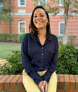 Headshot of Crystal Holloway sitting outside on a brick wall.