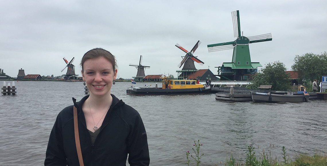 woman posing in front of windmills in the Netherlands on a study abroad experience