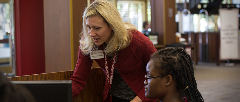 librarian helping a student on a computer in the Thomas Cooper Library