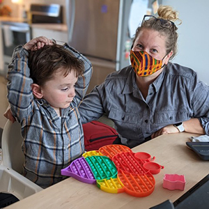 Caitlin Hudac sits with a young boy.