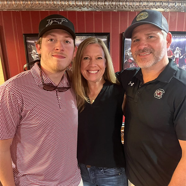 Conor Newsom, left, celebrates family weekend with his mother and father.